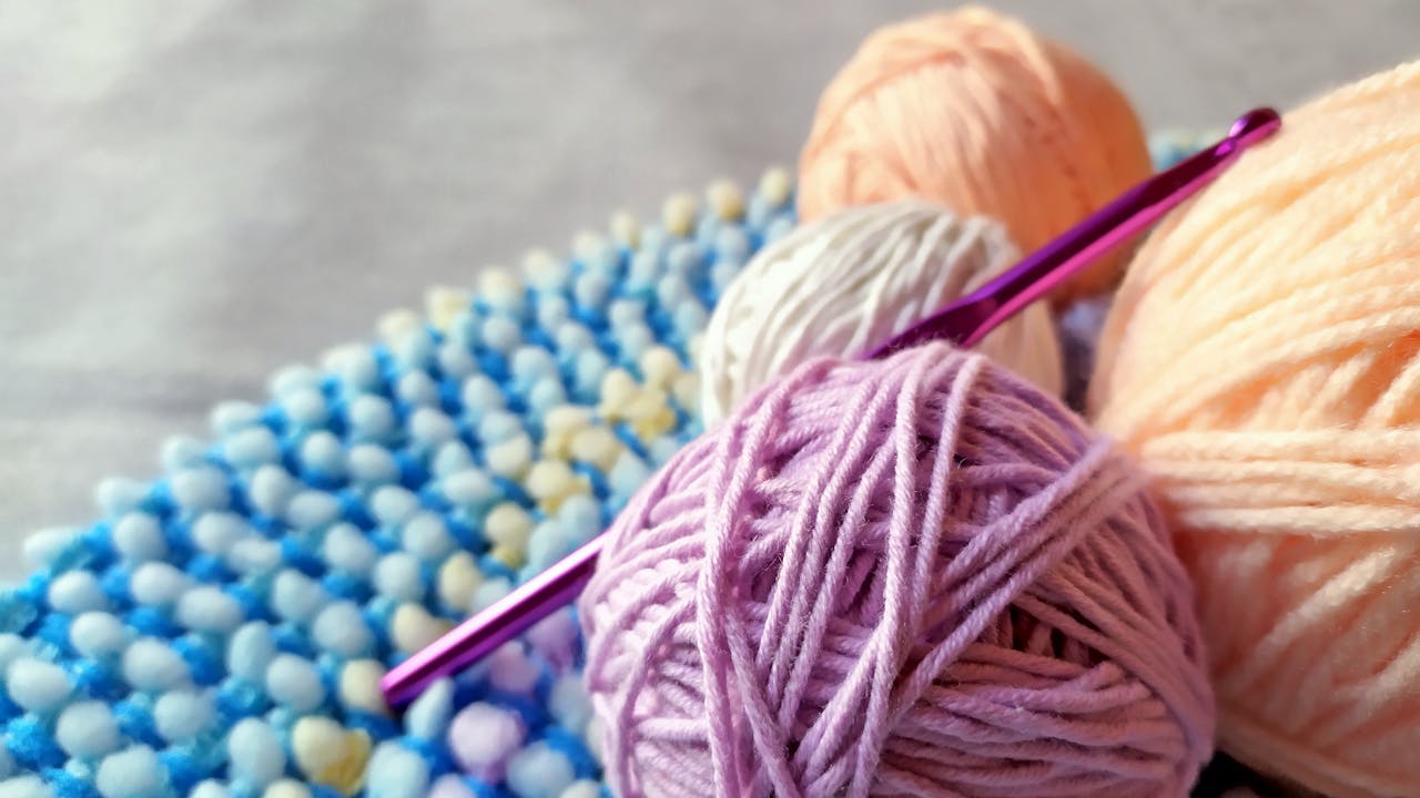 Learn Crochet Easily for Beginners Vibrant yarn and crochet hook on textured fabric. Perfect for craft projects.